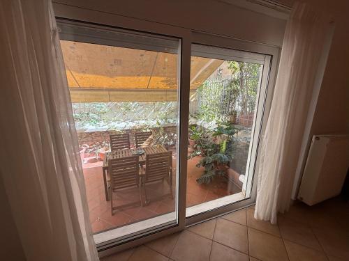 an open sliding glass door with a table and chairs on a patio at Casa Nikos in Athens