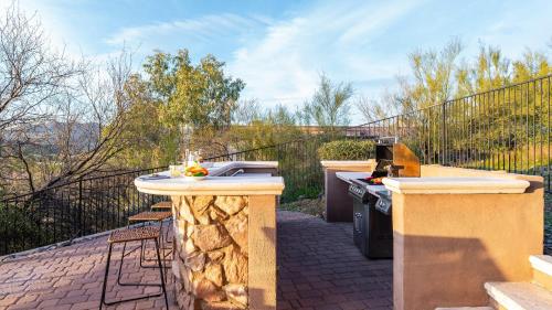 a outdoor kitchen with a grill and a stove at Sunbeam by AvantStay Elegant Private Desert Home w Infinity Pool Spa View in Cave Creek
