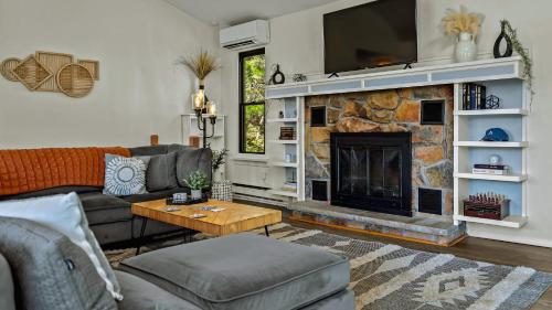 a living room with a couch and a fireplace at Lake It Right by AvantStay Lakefront w Dock Hot Tub Fire Pit Game Room in Long Pond