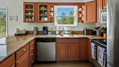 a kitchen with wooden cabinets and a sink at Lake It Right by AvantStay Lakefront w Dock Hot Tub Fire Pit Game Room in Long Pond