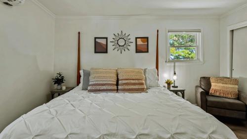 a large white bed in a bedroom with a window at Lake It Right by AvantStay Lakefront w Dock Hot Tub Fire Pit Game Room in Long Pond