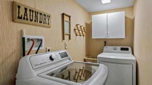 a laundry room with a sink and a washing machine at Lake It Right by AvantStay Lakefront w Dock Hot Tub Fire Pit Game Room in Long Pond