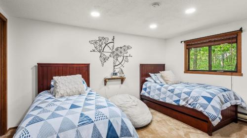 Crescent LakeThe Bears Den by AvantStay Prime Location Renovated w Movie Game Room的有两张床和一扇窗户的卧室