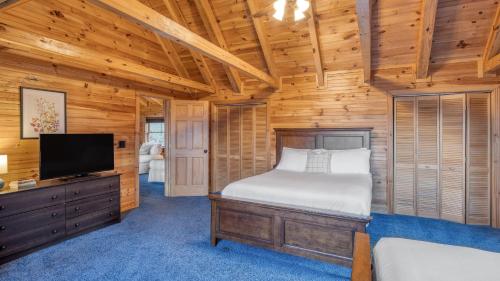 una camera da letto con un letto e una TV a schermo piatto di Leyland by AvantStay Cabin Mansion w Views ad Asheville