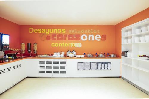 a restaurant kitchen with orange walls and a counter at One Ciudad de Mexico La Raza in Mexico City