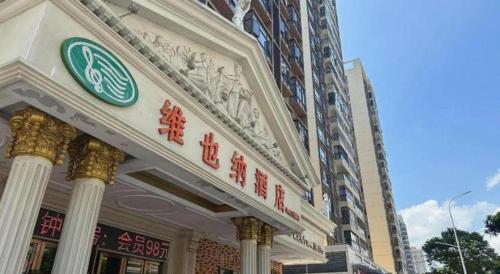 a building with a sign on the front of it at Vienna Hotel Guangdong Zhaoqing Sihui Tianguangxu in Zhaoqing