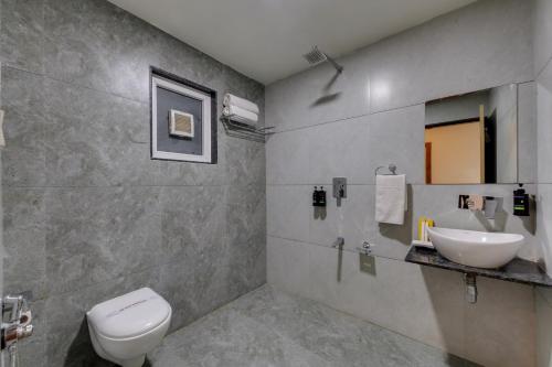 a bathroom with a white toilet and a sink at Hotel Sai Inn at Statue of Unity in Rājpīpla