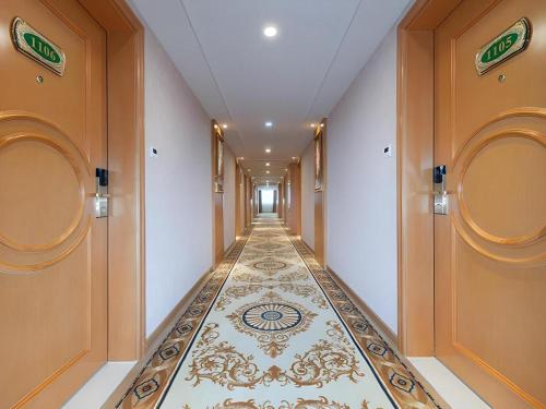 a hallway with a tile floor in a building at Vienna Hotel Guangxi Guilin Xing'an in Guilin