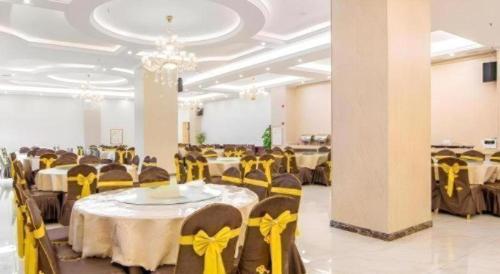 a banquet hall with tables and chairs with yellow bows at Vienna Hotel Guangxi Guilin Xing'an in Guilin