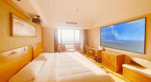 a bedroom with a large television on the wall at Vienna Hotel Guangxi Guilin Xing'an in Guilin