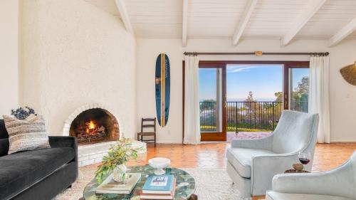 a living room with a couch and a fireplace at Dume Point by AvantStay Tennis Pool in Malibu in Malibu