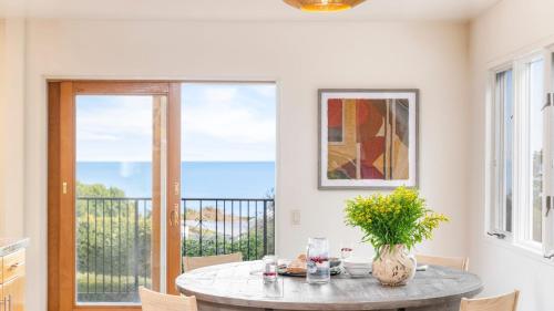 a dining room with a table with a view of the ocean at Dume Point by AvantStay Tennis Pool in Malibu in Malibu