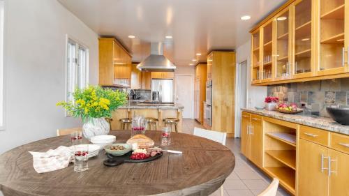 a kitchen with a large wooden table in a room at Dume Point by AvantStay Tennis Pool in Malibu in Malibu