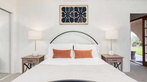 a bedroom with a large white bed with two lamps at Dume Point by AvantStay Tennis Pool in Malibu in Malibu