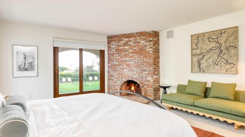 a bedroom with a fireplace and a bed and a couch at Dume Point by AvantStay Tennis Pool in Malibu in Malibu