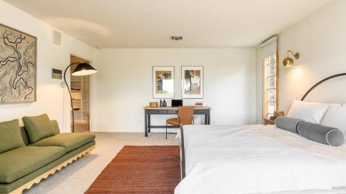 a bedroom with a bed and a couch and a desk at Dume Point by AvantStay Tennis Pool in Malibu in Malibu