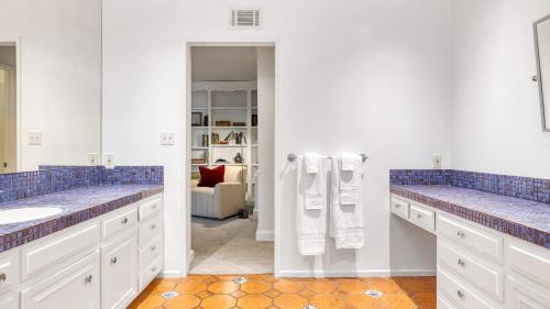 a bathroom with two sinks and blue tiles at Dume Point by AvantStay Tennis Pool in Malibu in Malibu