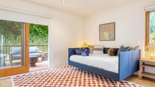 a bedroom with a blue bed and a balcony at Dume Point by AvantStay Tennis Pool in Malibu in Malibu
