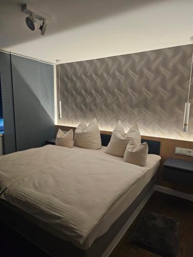 une chambre avec un grand lit avec des oreillers blancs dans l'établissement Costyn Apartments 1, à NuÃŸbaum