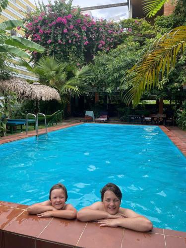 two girls laying in a swimming pool at Phong Nha Dawn Home in Phong Nha