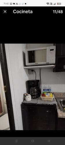 a kitchen with a microwave and a coffee maker at Mini departamento Aire acondicionado y factura in La Armonía