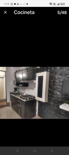 a kitchen with a stove and a microwave at Mini departamento Aire acondicionado y factura in La Armonía