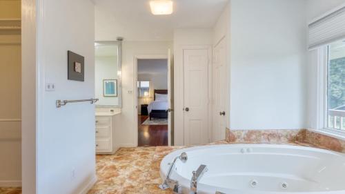 una bañera en un baño con ventana en Amber Lodge by AvantStay Pool Firepit Sauna, en Jefferson City