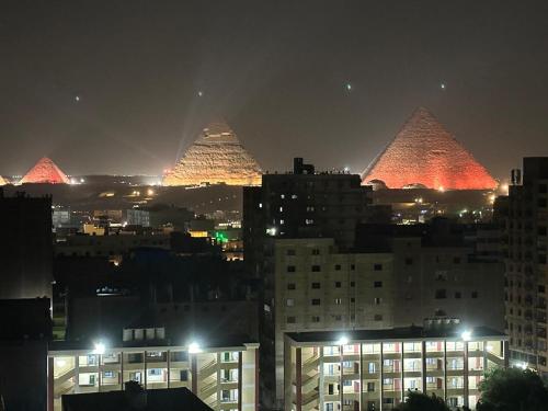 a view of pyramids in a city at night at Pyramids sun set view in Cairo