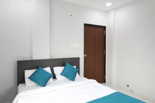 a bedroom with a large white bed with blue pillows at Azura Vista by Alt Acco in Pune
