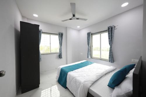 a bedroom with a bed and two windows at Azura Vista by Alt Acco in Pune
