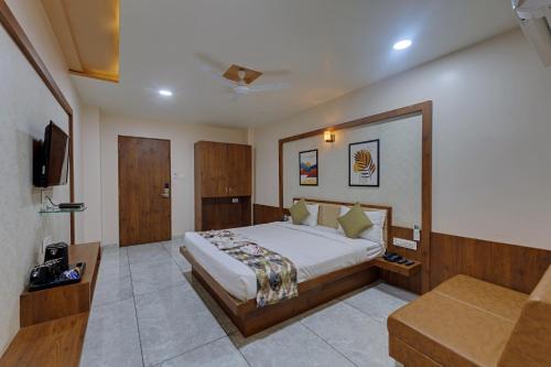 a bedroom with a large bed and a couch at Hotel Sai Inn at Statue of Unity in Rājpīpla