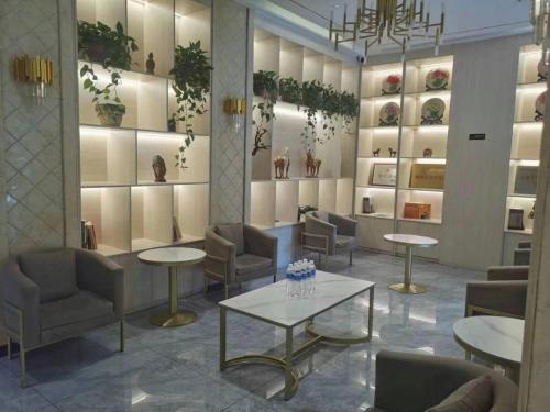 a waiting room with tables and chairs and vases at GreenTree Inn Luoyang Henan University of Science and Technology in Luoyang