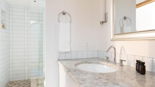 une salle de bain blanche avec un lavabo et un miroir dans l'établissement Pandora by AvantStay Modern Mountain Escape in Great Location @ Entrance of Bear Creek Trail, à Telluride