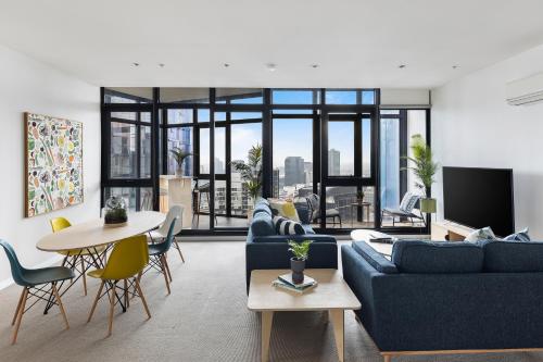 a living room with a blue couch and a table at Nook Melbourne Apartments in Melbourne