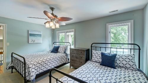 a bedroom with two beds and a ceiling fan at Lakefront w Private Dock Hot Tub Pontoon Rental Butler Bliss by AvantStay in Sherrills Ford