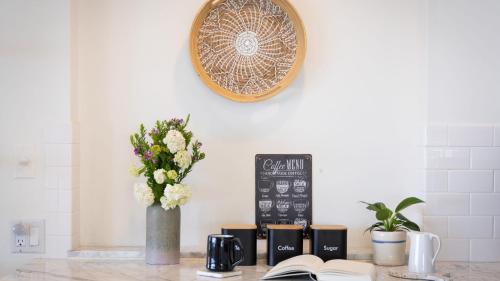 a table with books and a vase of flowers and a clock at Stardust by AvantStay Views Hot Tub Pool Table in Malibu