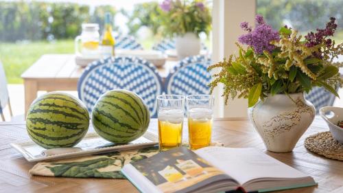 a table with two water melons and two glasses of beer at Stardust by AvantStay Views Hot Tub Pool Table in Malibu