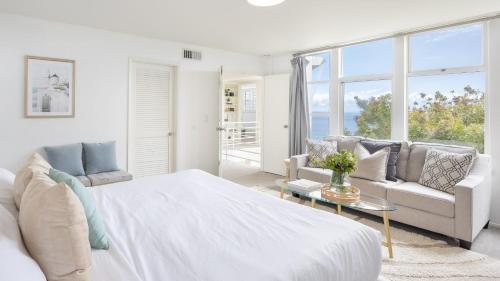 a white bedroom with a large bed and a couch at Stardust by AvantStay Views Hot Tub Pool Table in Malibu
