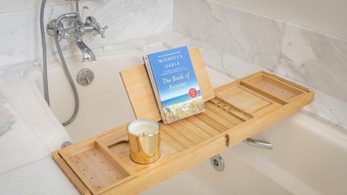 a book sitting on a wooden tray in a bath tub at Stardust by AvantStay Views Hot Tub Pool Table in Malibu
