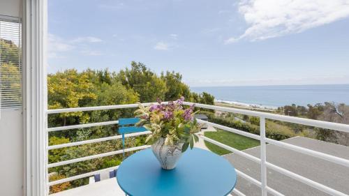 a vase of flowers sitting on a table on a balcony at Stardust by AvantStay Views Hot Tub Pool Table in Malibu
