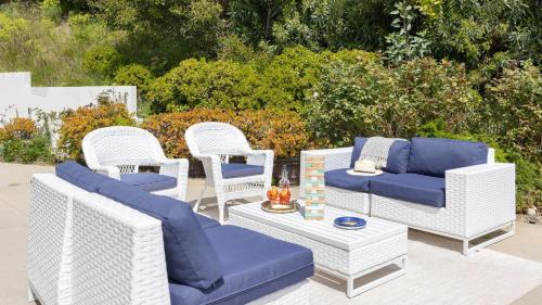 a group of wicker chairs and couches on a patio at Stardust by AvantStay Views Hot Tub Pool Table in Malibu