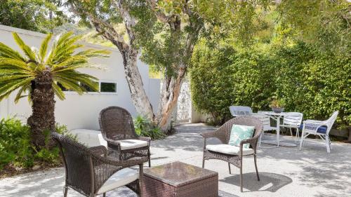 a patio with chairs and a table and trees at Stardust by AvantStay Views Hot Tub Pool Table in Malibu