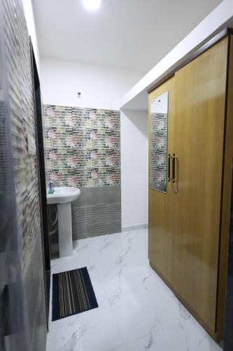 a bathroom with a wooden door and a sink at Azura Vista by Alt Acco in Pune