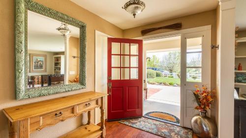 Una puerta roja en Aoyer con un espejo. en Olive Ranch by AvantStay Enjoy Sunsets over the Valley 4.5 Acre Ranch Home, en Paso Robles