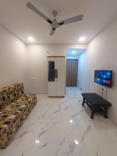 a living room with a table and a ceiling fan at Azura Vista by Alt Acco in Pune