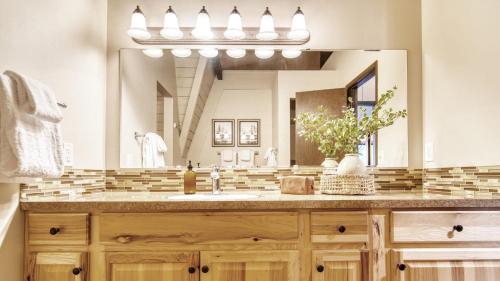 a bathroom with a sink and a large mirror at Alder by AvantStay Moody Retreat: Patio Hot Tub in Sunriver in Sunriver