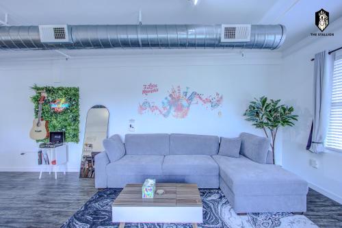 a living room with a couch and a table at The Stallion #305 - Walk to Attractions - Modern Spacious 1BD Loft in Memphis Downtown in Memphis