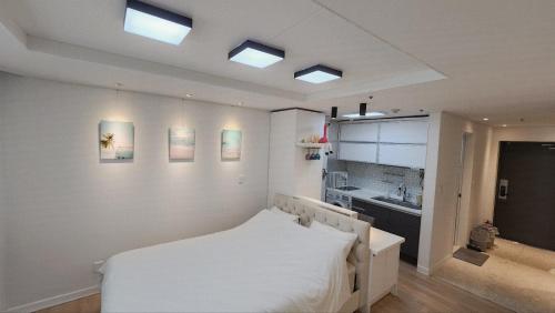 a bedroom with a white bed and a sink at Marine City Cozy Stay in Busan
