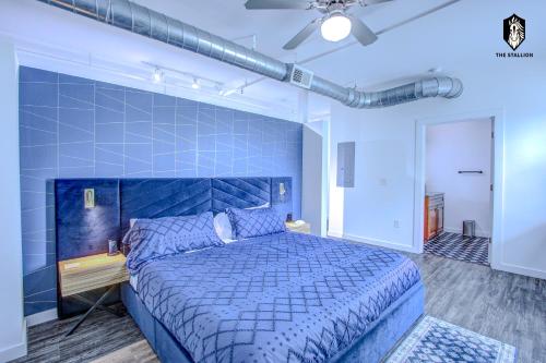 a blue bedroom with a large bed with a blue headboard at The Stallion #305 - Walk to Attractions - Modern Spacious 1BD Loft in Memphis Downtown in Memphis
