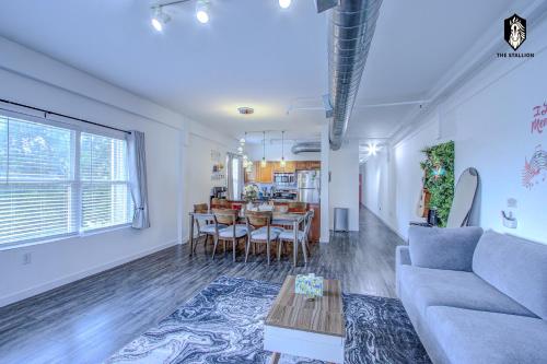 a living room with a couch and a table at The Stallion #305 - Walk to Attractions - Modern Spacious 1BD Loft in Memphis Downtown in Memphis